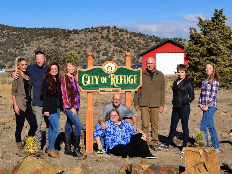 Founders of City of Refuge standing next to the City of Refuge sign