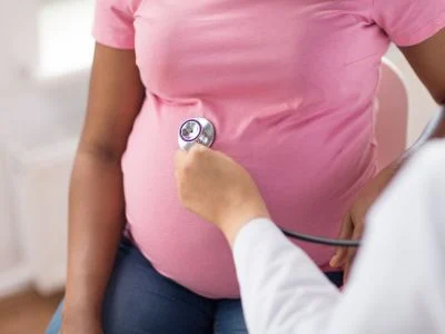 Pregnant woman receiving prenatal care from a doctor