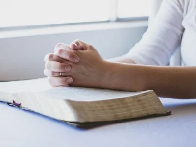 woman praying with a Bible